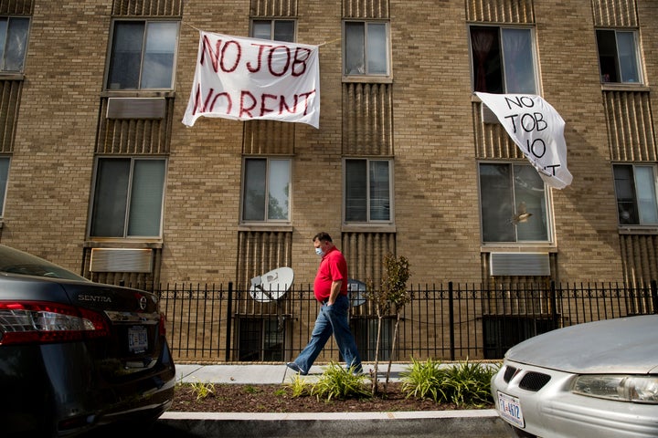 Signs that read "No job, no rent" hang from the windows of an apartment building in northwest Washington, D.C., in May. The pandemic shut housing courts and prompted policies protecting renters from eviction. But not everyone is covered, and now many are coming to an end.