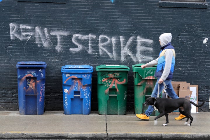 A pedestrian walks past graffiti in Seattle's Capitol Hill neighborhood. With millions of people suddenly out of work, some tenants in the U.S. have gone on a rent strike. Some cities have temporarily banned evictions, but advocates for the strike are demanding that rent payments be waived, not delayed, for those in need during the crisis.