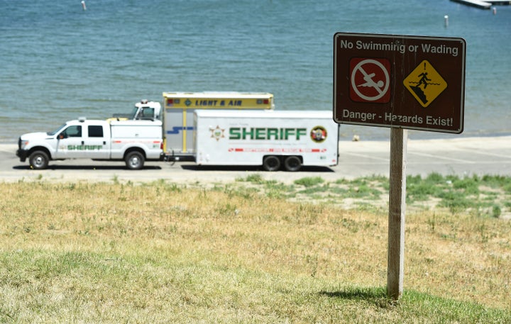 A sign warns of safety hazards as members of the Ventura County Sheriff's Underwater Search and Rescue Team search Thursday for former 'Glee' actor Naya Rivera in Lake Piru, in Southern California.