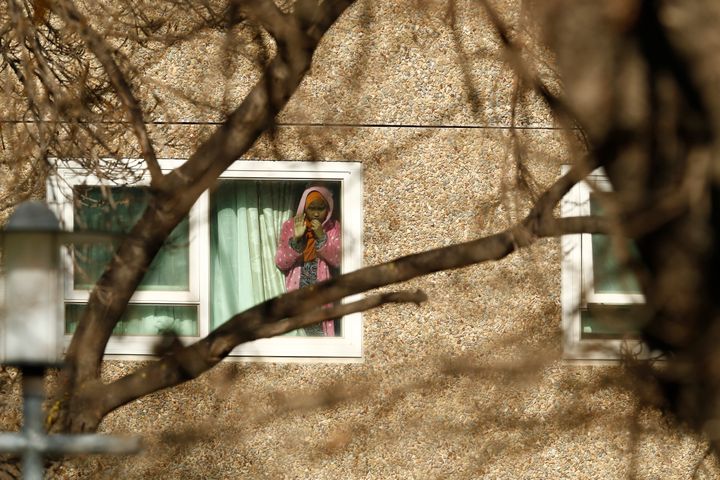 A girl looks out a window of the North Melbourne Public Housing tower complex on July 8. Residents of the complex, deemed a coronavirus hotspot, were kept inside on a police-enforced lockdown for six days.