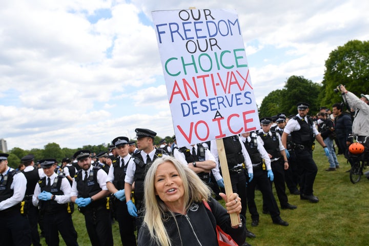 Une manifestante brandit une pancarte portant un slogan antivaccination pendant une manifestation contre le confinement lié au coronavirus à Hyde Park, à Londres, le 16 mai 2020