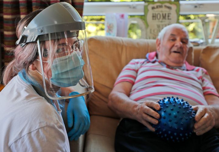 A nurse in PPE speaks to a resident at the Wren Hall care home in Nottingham