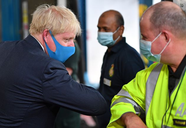 Prime Minister Boris Johnson, wearing a face mask, elbow bumps AA employee Richard during a visit to the headquarters of the London Ambulance Service NHS Trust.