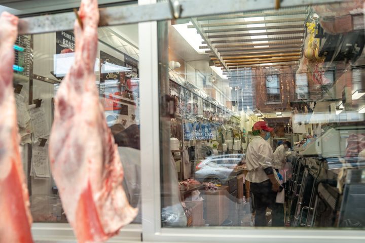 Pork legs hang in the window display at Vincents Meat Market on April 17 in the Bronx borough of New York City.