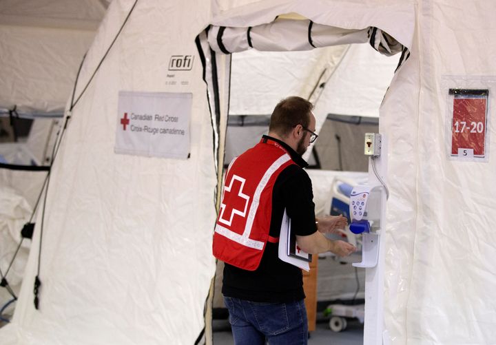 A volunteer cleans his hands as he enters a tent in a mobile hospital set up in partnership with the Canadian Red Cross in the Jacques-Lemaire Arena to help care for patients with the coronavirus disease (COVID-19) from long-term centres (CHSLDs), in Montreal on April 26, 2020. 