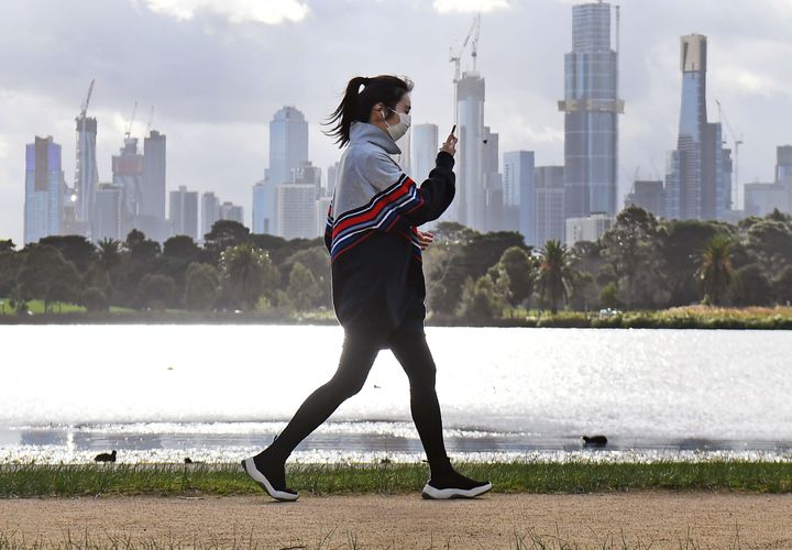 A woman exercises along Albert Park lake in Melbourne on July 13, 2020, as five million people in Australia's second-biggest city began a new lockdown following a resurgence of coronavirus cases. (Photo by William WEST / AFP) (Photo by WILLIAM WEST/AFP via Getty Images)