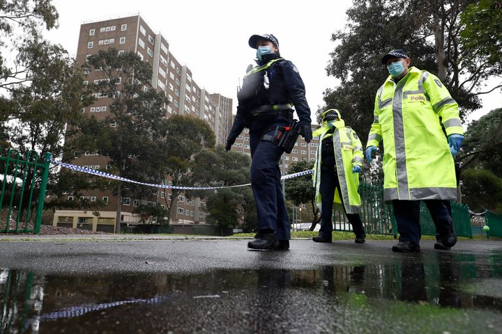 Members of the Victoria police patrol outside a public housing tower that was placed under "hard lockdown" in Melbourne on July 11, 2020.