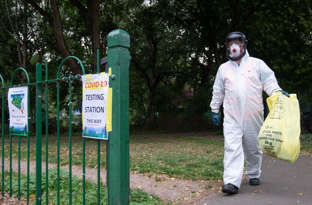 A worker for Leicester City Council carries a bag of clinical waste away from a Covid-19 testing station. 