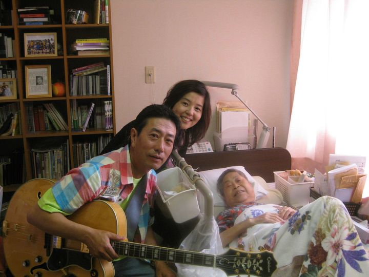 沼田鈴子さんに捧げる歌「アオギリにたくして」を、ベット横で演奏した＝2010年7月