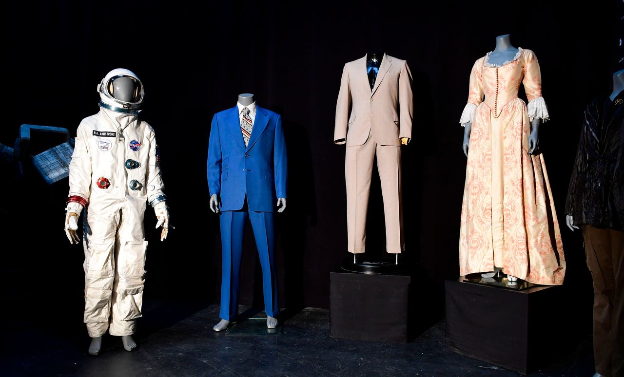 Από αριστερά: Η στολή του Νιλ Άρμστρονγκ που φορούσε ο Ράιαν Γκόσλινγκ στην ταινία «Ο Πρώτος Άνθρωπος», το μπλέ κουστούμι του Γουίλ Φάρελ από την ταινία «Anchorman», το λευκό κουστούμι του Αλ Πατσίνο από την ταινία ο «Νονός 2» και τέλος το φόρεμα της Κίρα Νάιτλι από την ταινία «Οι Πειρατές της Καραϊβικής».