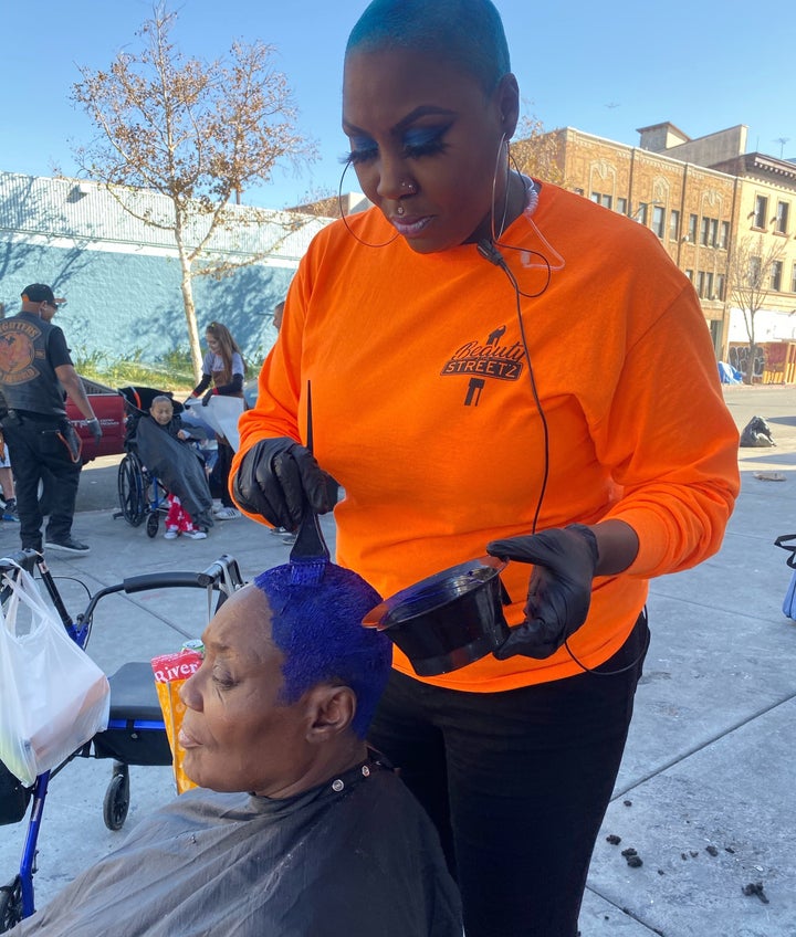 Shirley Raines applies color to a client's hair on the streets of Los Angeles.