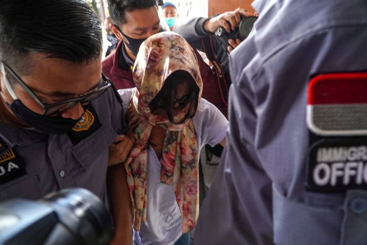 Sara Connor, an-49-year-old Australian woman, who was sentenced to four years imprisonment over the death of a policeman, being escorted by Indonesian Immigration officers after she was given early release in Badung, Bali, Indonesia, July 16, 2020 in this photo taken by Antara Foto. Antara Foto/DP. Herdyanto/ via REUTERS