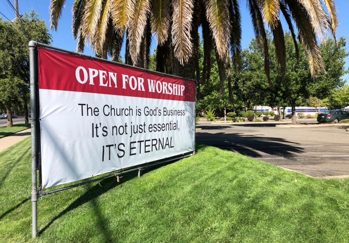 An "Open for Worship" banner is posted July 9 outside the Crossroads Community Church in Yuba City, Calif.