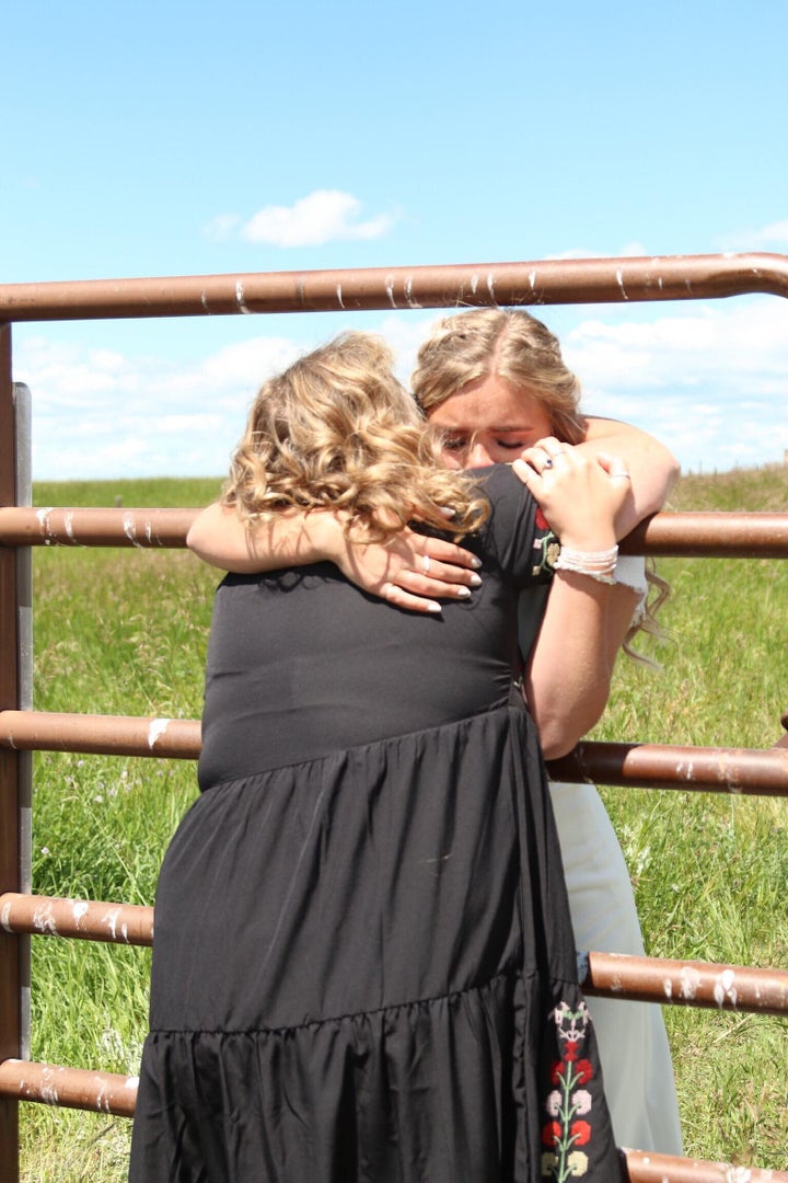 Kadee Jensen hugs her mother through a fence at the Alberta-Montana border on her wedding day.