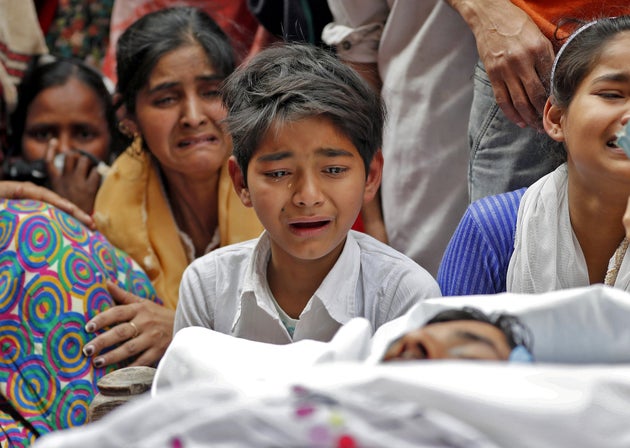  People mourn next to the body of Muddasir Khan, who was wounded on Tuesday in a clash between people...
