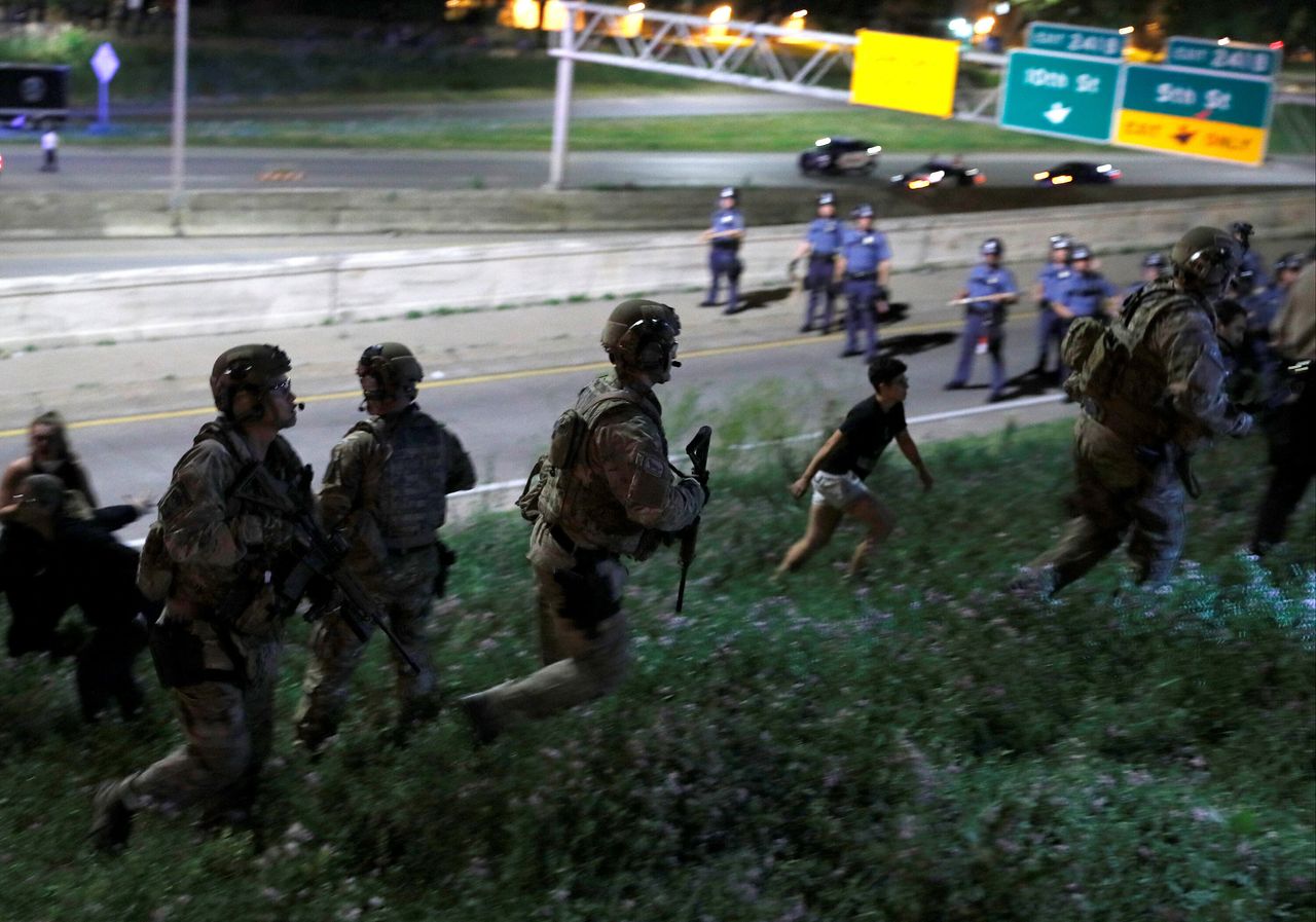 SWAT officers in riot gear chase down police brutality protesters in St. Paul, Minnesota, in June 2017. The increasing aggressiveness and militarization of police has far-reaching consequences for their ability to solve crimes.