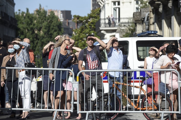 People watch as firefighters are at work to put out a fire at the Saint-Pierre-et-Saint-Paul cathedral.