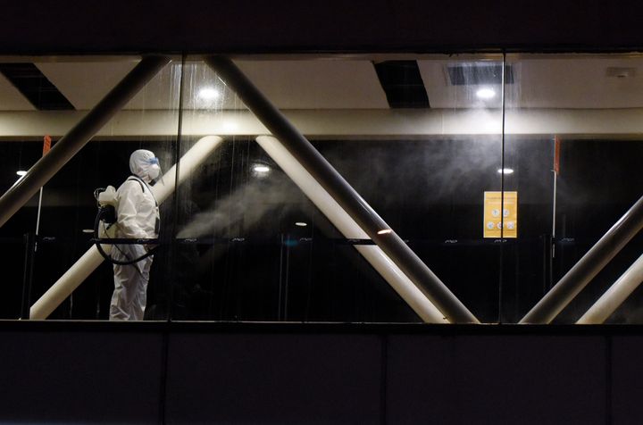 A worker disinfects the terminal where passengers will disembark after docking in Montevideo, Uruguay.