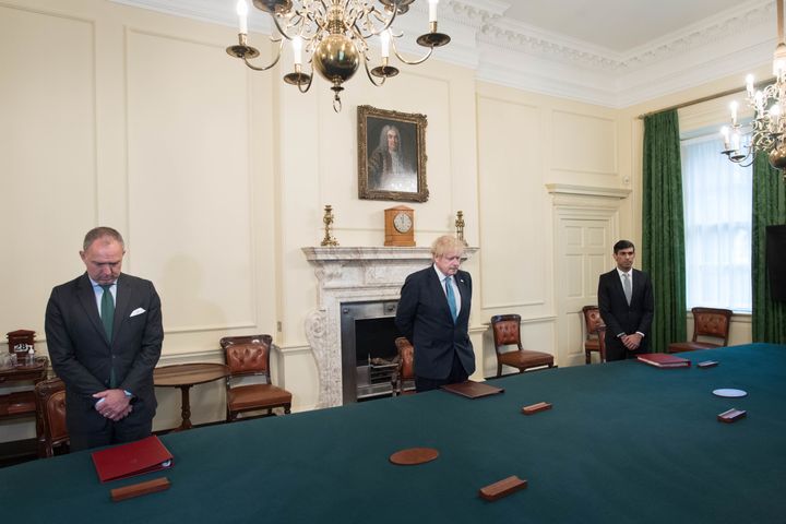 While socially distancing, Boris Johnson (centre) stands with cabinet secretary Sir Mark Sedwill (left) and chancellor Rishi Sunak (far right) in the cabinet room inside 10 Downing Street to observe a minute's silence in a tribute to the NHS staff and key workers who have died during the coronavirus outbreak