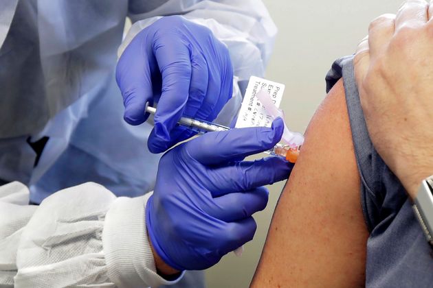 A volunteer receives a shot in the first-stage safety study clinical trial of a potential vaccine in Seattle.