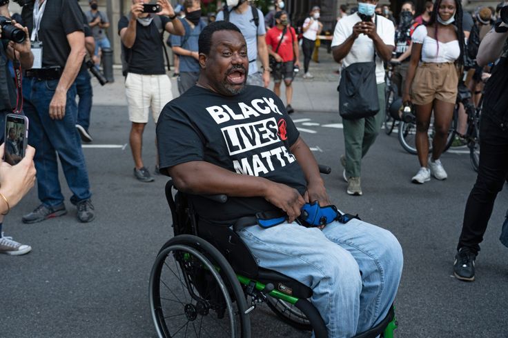 A Black Lives Matter protester in a wheelchair leads others in chanting during a rally outside New York City Hall in July.