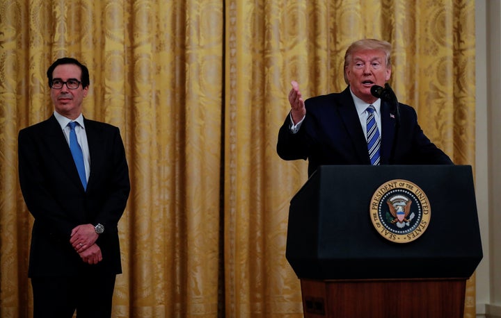 Treasury Secretary Steven Mnuchin (left) sought to keep the names of Paycheck Protection Program recipients secret for weeks. On April 28, he watched as President Donald Trump spoke about PPP loans in the White House East Room.