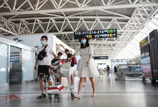 Dos turistas en el aeropuesto de Sanyan (Sha Xiaofeng/VCG via Getty
