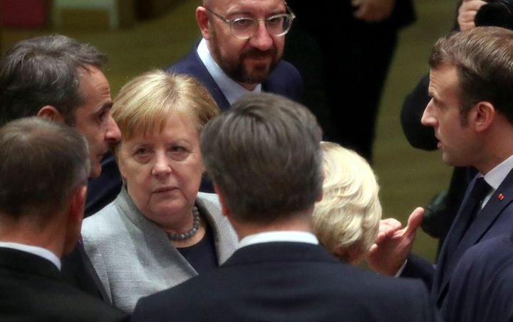 German Chancellor Angela Merkel, third left, speaks with Greek Prime Minister Kyriakos Mitsotakis, left, and French President Emmanuel Macron, right, during an EU summit in Brussels, Friday, Feb. 21, 2020. Major contributors to the European Union's budget blocked progress at an emergency summit on Friday, insisting that they would not stump up more funds for the bloc's next long-term spending package. (Yves Herman, Pool Photo via AP)