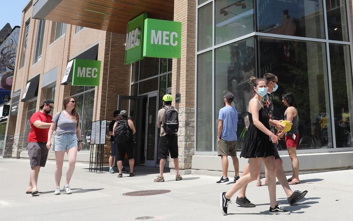 People line up to enter the Mountain Equipment Co-op (MEC) store at Queen and John streets in Toronto, May 25, 2020. Canadians are actually spending more today than they were before the pandemic, despite large job losses.