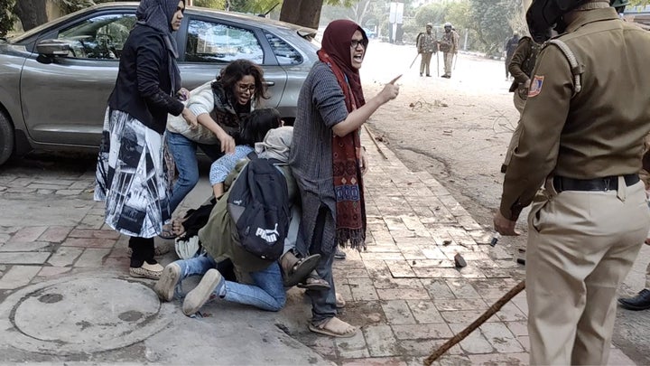 Women form a human shield around a man beaten by police during protests against new citizenship law, at Jamia Millia Islamia University in New Delhi, December 15, 2019 in this screen grab obtained from a social media video.