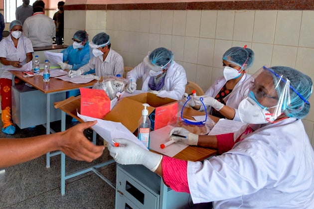 Medical professionals issue modules to members of the media before getting tested for Covid-19 at the...