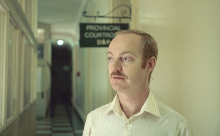 Dennis Findlay standing in the hallway outside a courtroom at Queen Street Court House, where legal proceedings following the 1981 bathhouse raids took place.