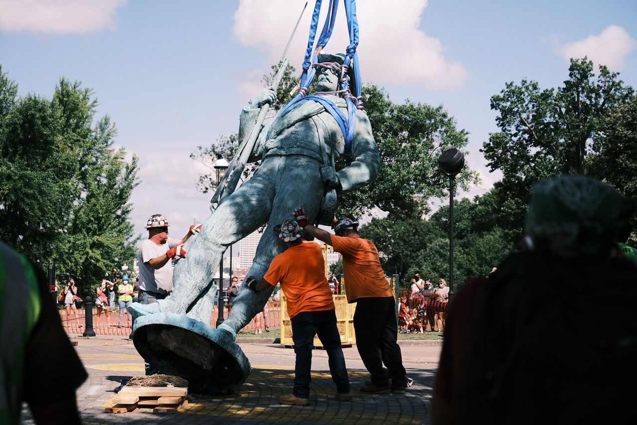 Workers in Richmond prepare to load a monument to Confederate soldiers and sailors onto a flatbed truck on July 8, 2020.