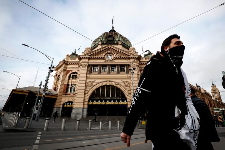 As Melbourne's metropolitan area continues to face COVID-19 restrictions, a man is seen wearing a face mask out Flinders Street Station on July 23, 2020 in the Victorian capital. 