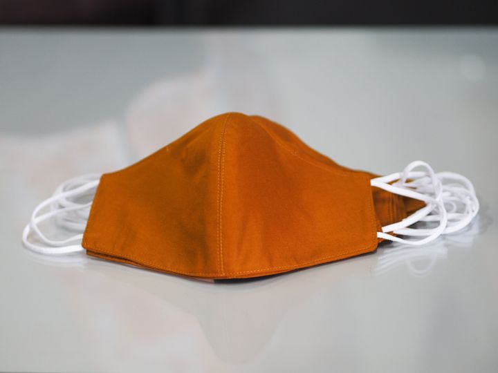 Brown color mask self prevention ill on desk made of fabric for protect dust and germs pm 2.5, coronavirus covid-19