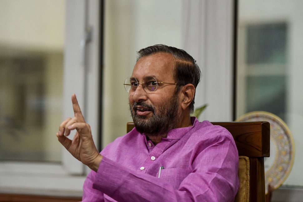 Prakash Javadekar, Indian Minister of Environment, Forests and Climate Change, Minister of Information and Broadcasting and Minister of Heavy Industries and Public Enterprises, gestures as he speaks with media representatives at his office in New Delhi. 