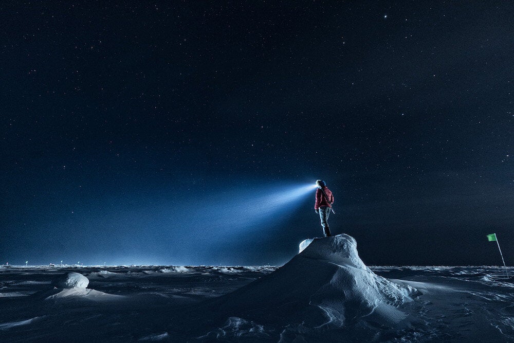 A polar bear guard stands watch on an ice ridge.