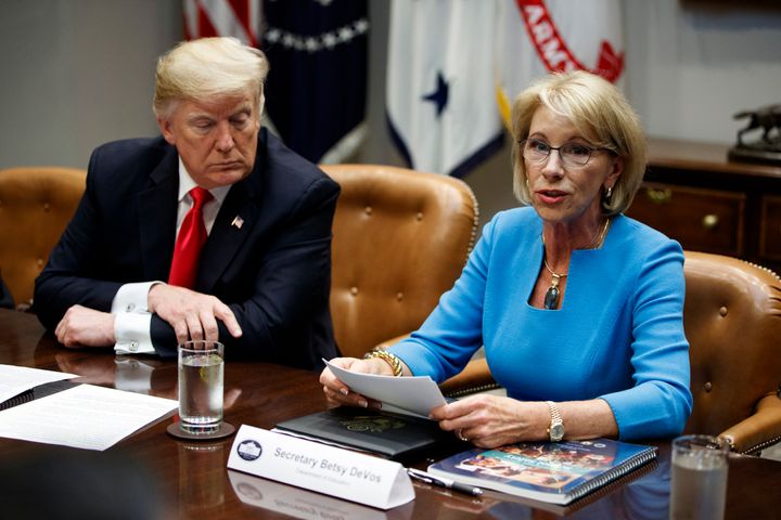 President Donald Trump listens as Education Secretary Betsy DeVos speaks during a roundtable discussion on the Federal Commission on School Safety report in 2018.