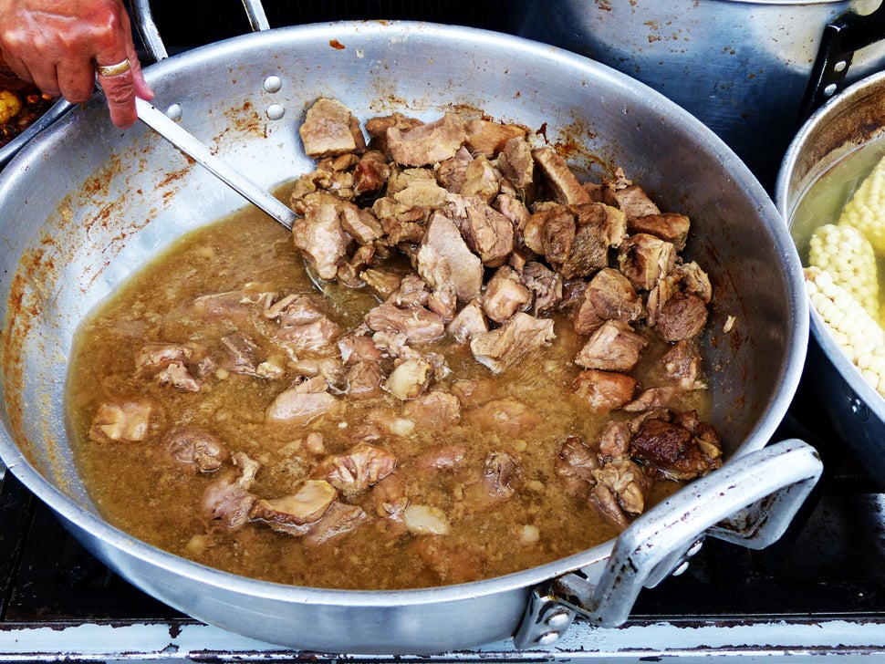 Big metal bowl of Fritada, fried pork meat, traditional homemade ecuadorian and andean typical food. Top view.