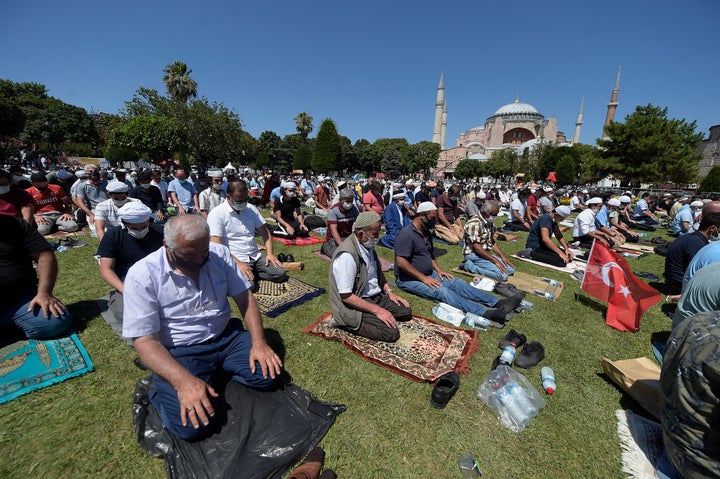 Muslims pray during Friday prayers in the historic Sultanahmet district of Istanbul, near the Byzantine-era Hagia Sophia, in the background, on Friday, July 24, 2020.