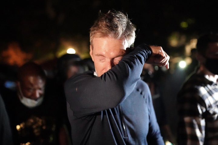 Portland Mayor Ted Wheeler reacts after being exposed to tear gas fired by federal officers while attending a protest against