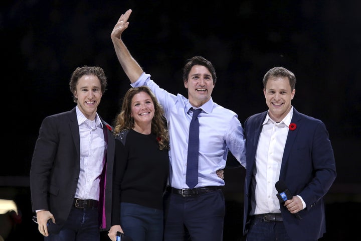 Prime Minister Justin Trudeau waves while on stage with his wife Sophie and WE Day co-founders Craig Kielburger (left) and Marc Kielburger (right) during a WE Day event in Ottawa on Nov. 10, 2015. 