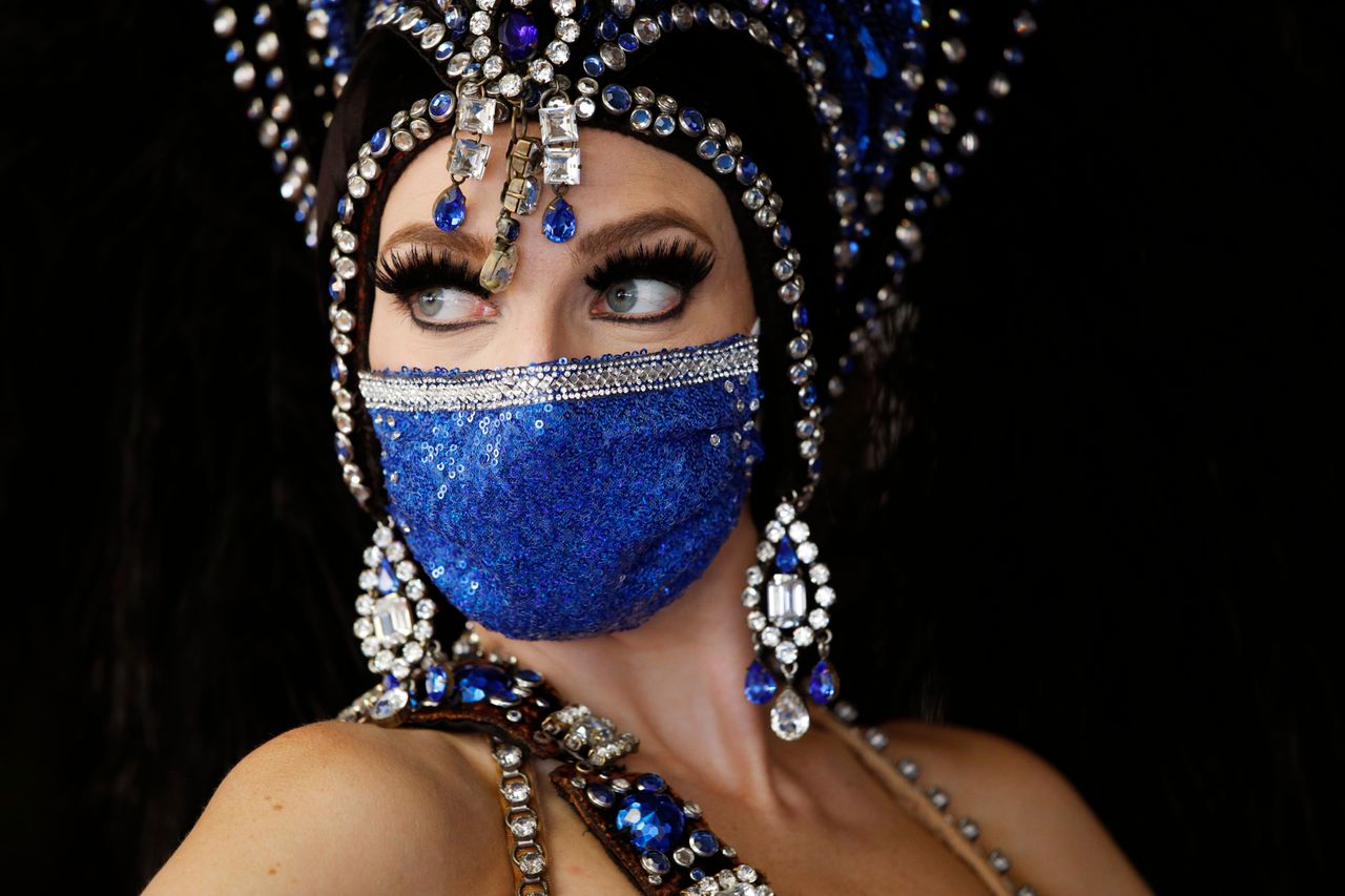 A show performer in a face mask stands by the door at the reopening of Bally's Las Vegas hotel and casino, Thursday, July 23, 2020, in Las Vegas. The casino reopened for the first time since March following a closure to prevent the spread of the coronavirus. 