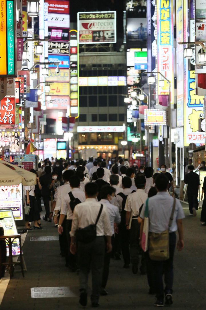 風営法に基づく警視庁の立ち入りと合同で、新型コロナウイルス感染防止対策の周知のため歌舞伎町の店舗に向かう東京都の職員ら＝7月24日午後、東京都新宿区