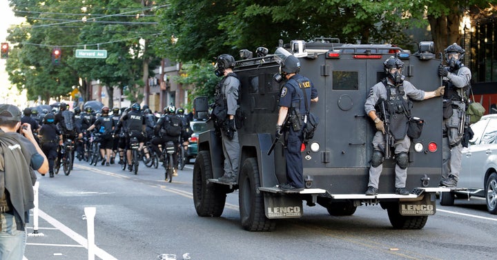 Seattle Police ride on a vehicle behind bicycle police during a Black Lives Matter protest march, Saturday, July 25, 2020, in Seattle.