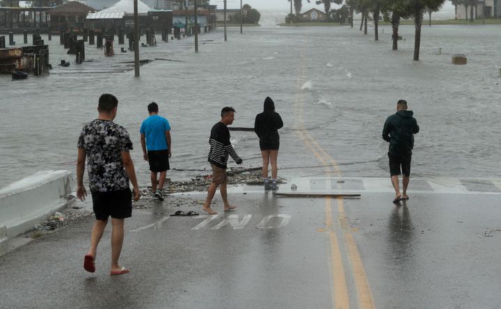 Onlookers gather on a road beginning to flood as Hurricane Hanna makes landfall, Saturday, July 25, 2020, in Corpus Christi, Texas. (AP Photo/Eric Gay)
