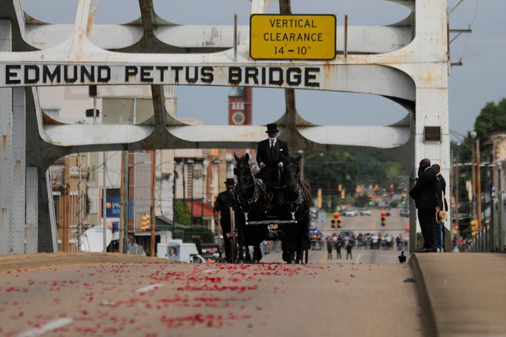 The casket of Rep. John Lewis moves over the Edmund Pettus Bridge by horse-drawn carriage during a memorial service for Lewis, Sunday, July 26, 2020, in Selma, Ala. (AP Photo/Brynn Anderson)