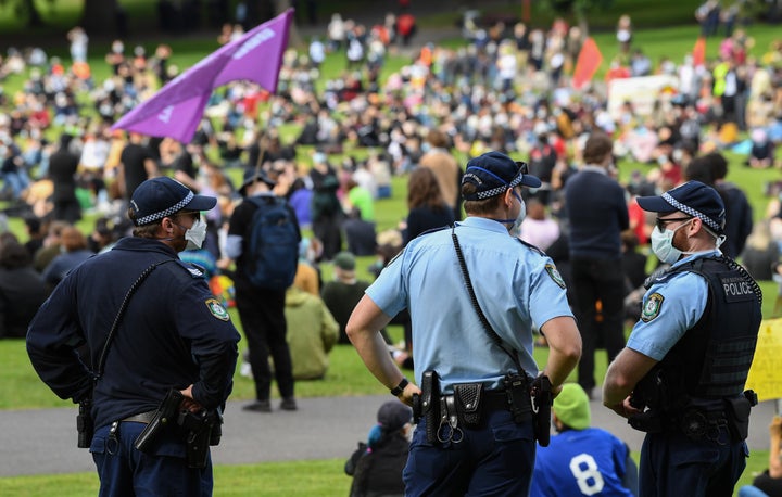 SYDNEY, AUSTRALIA - JULY 05: Police wearing face masks watch people gather at a rally against Black Deaths in Custody in The Domain on July 05, 2020 in Sydney, Australia. 