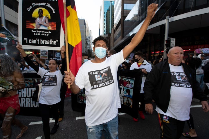 BLM protesters march and hold up signs from Sydney Town Hall along Castlereagh St to Belmore Park on 06 June, 2020 in Sydney, Australia. 