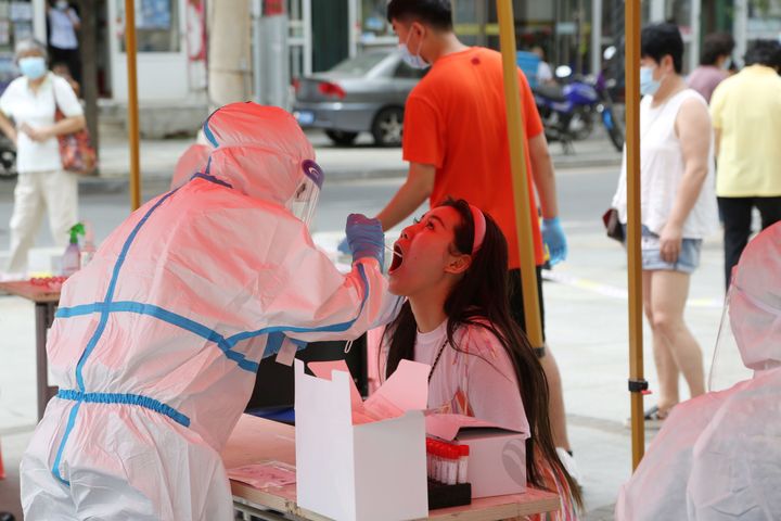 A health worker carries out a Covid-19 test at a makeshift testing centre in Dalian, in China's northeast Liaoning province on July 27, 2020.